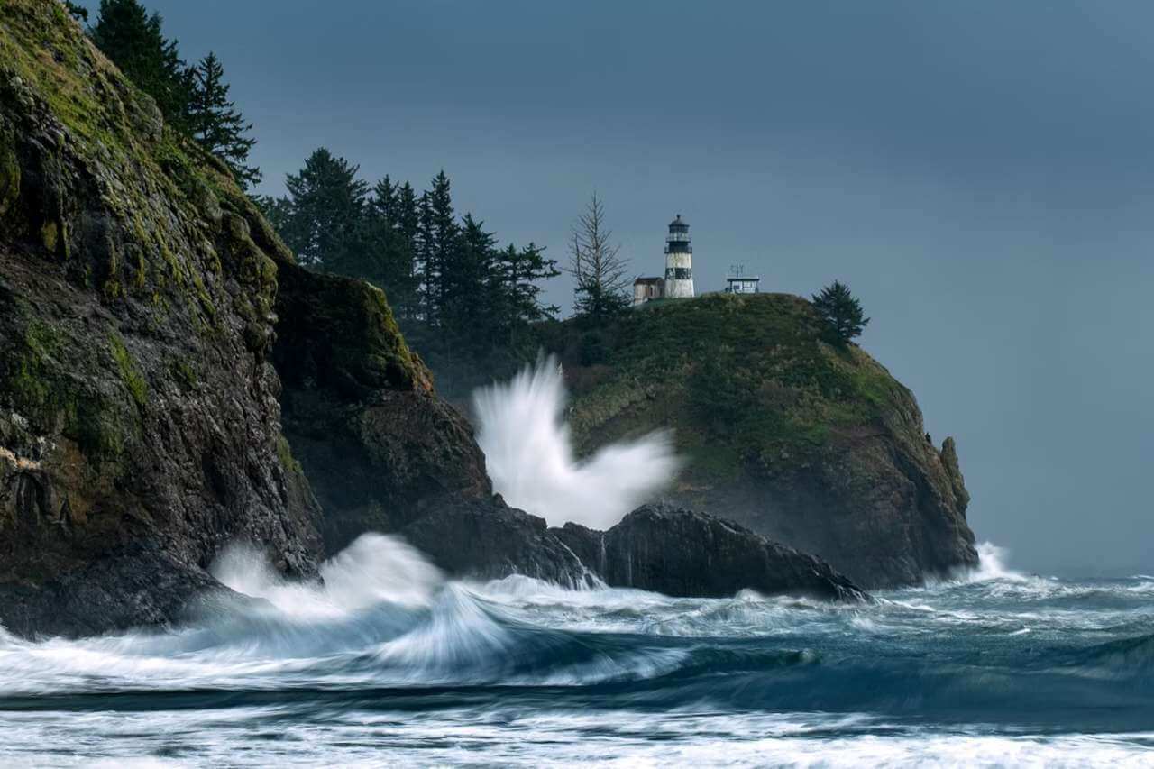 High surf crashing below Cape Disappointment Lighthouse during winter storm watching