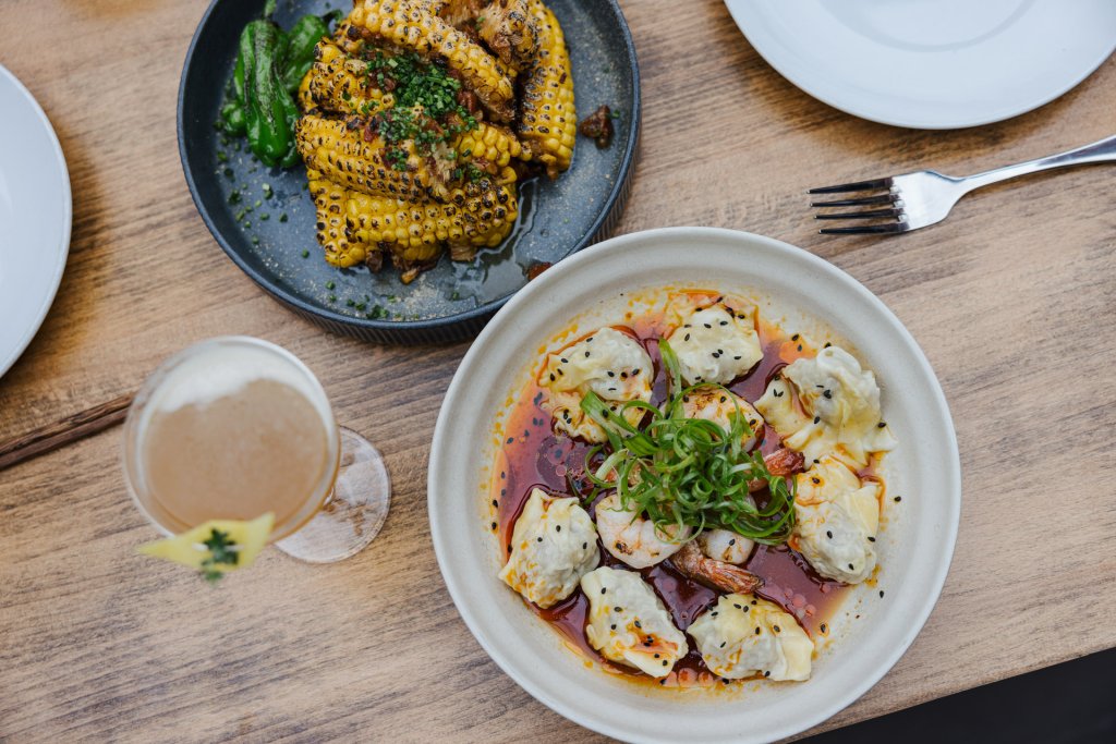 Charred corn, dumplings and a cocktail on a table at Ba Sa Restaurant